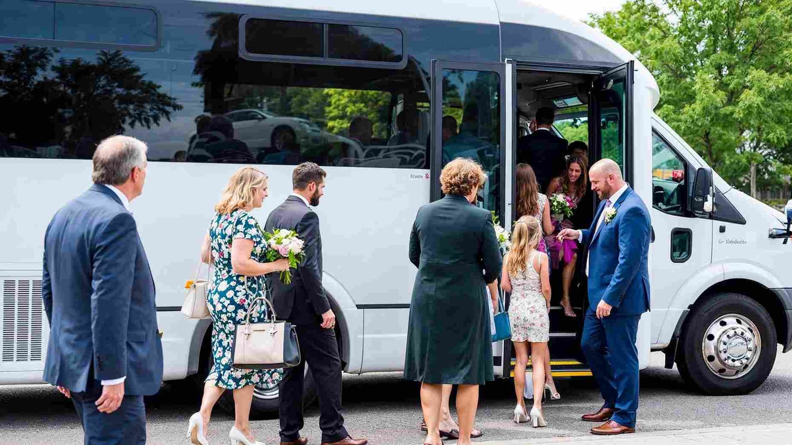 A group boarding a shuttle outside a hotel