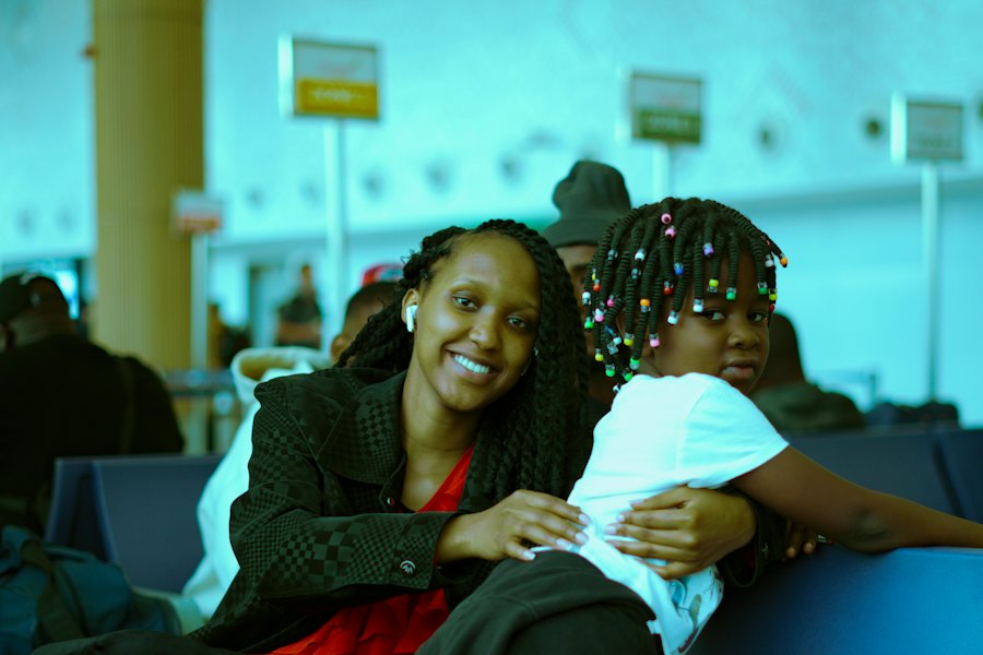 A parent and child waiting together in an airport terminal