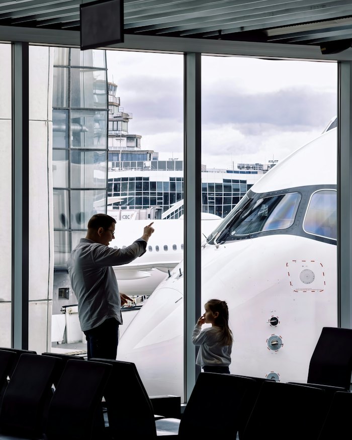 A parent and child at the terminal window before a flight